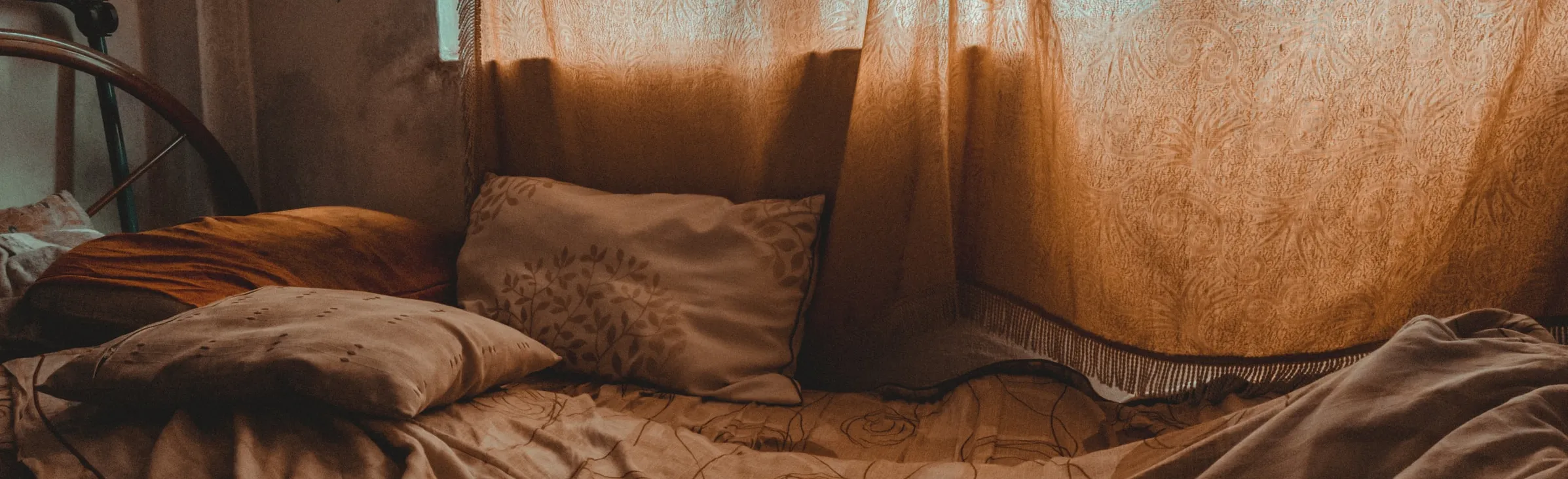 Bed with cushions and curtains closed