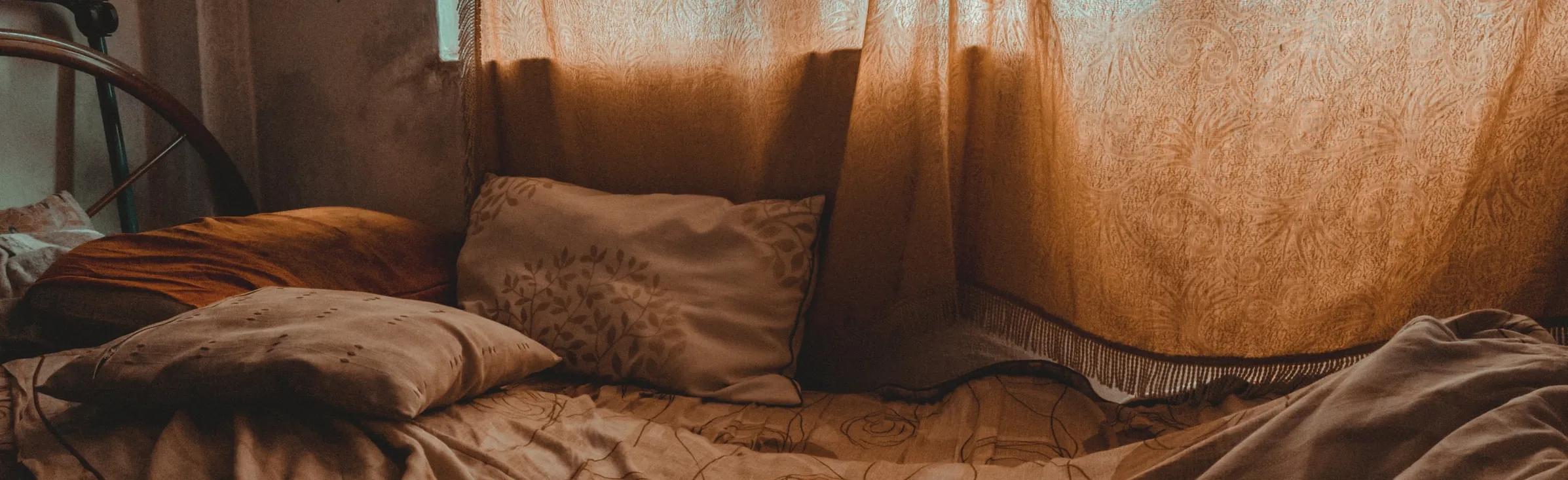 Bed with cushions and curtains closed